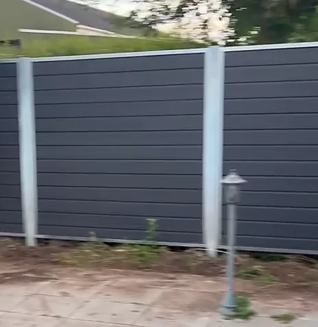 Nyt komposithegn med aluminiumsstolper i en have